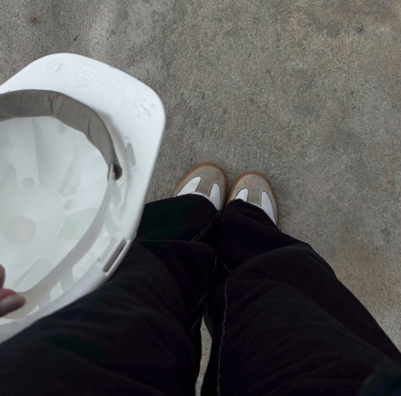 Visita técnica a uma obra acompanhada pela Arquitetura Clara, com capacete de segurança sobre piso de concreto